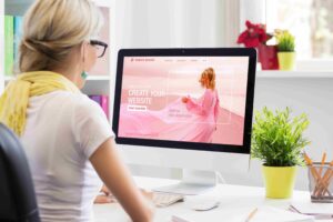 Žena pravi sajt na računaru koristeći website builder