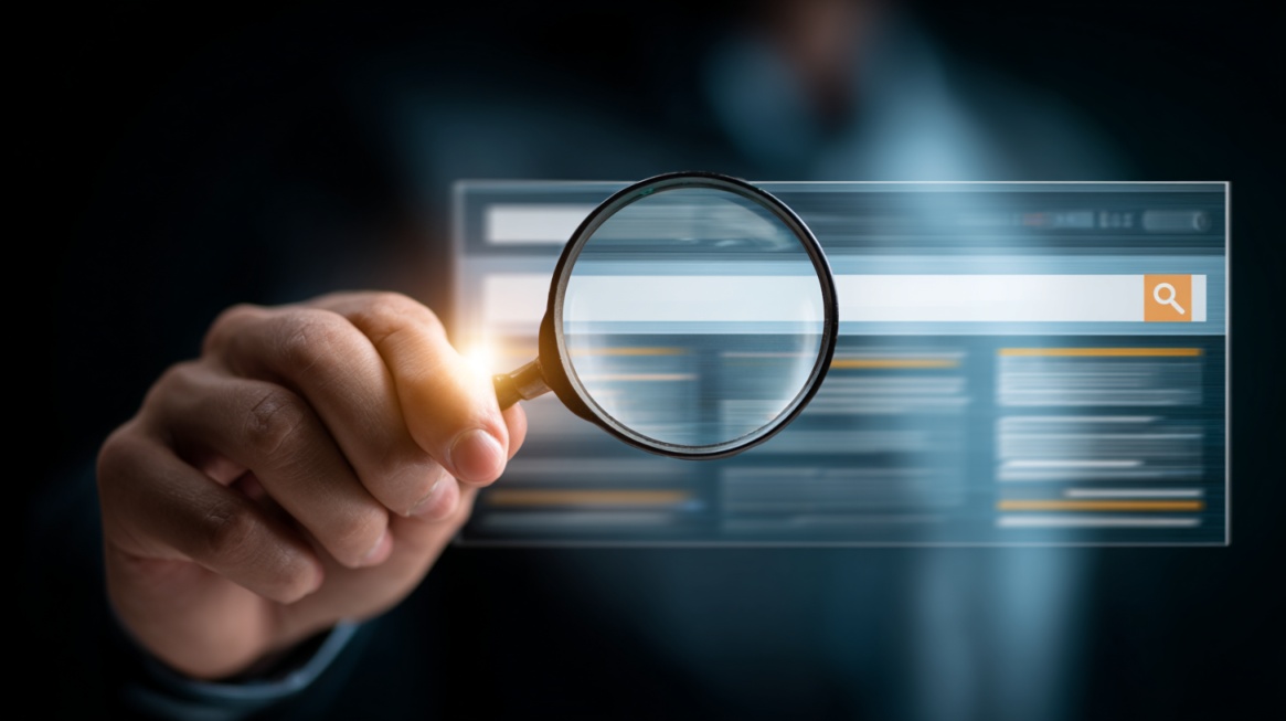 Ruka drži lupu ispred pretraživača na ekranu